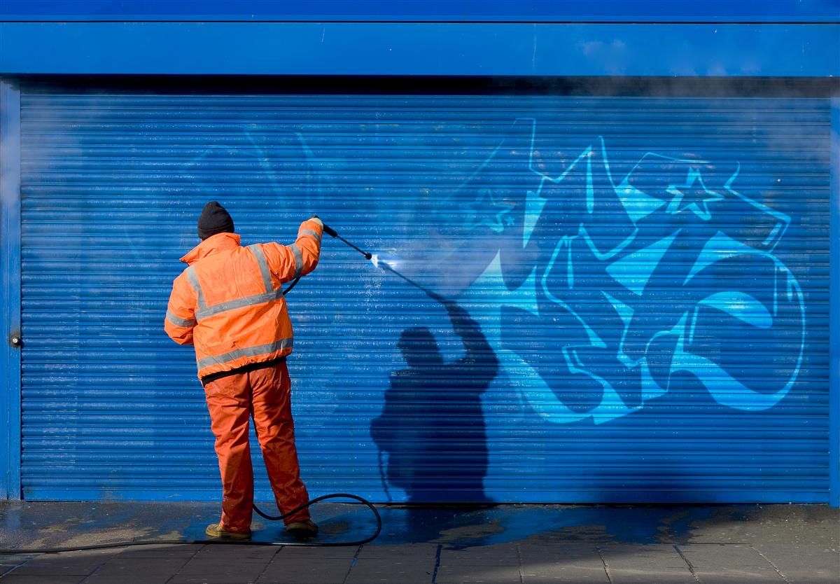 Graffitientfernung an einem Rolltor mit Hochdrucktechnik