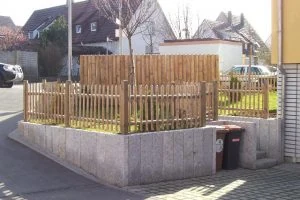 Umlaufende Stützmauer aus Granitblöcken an einer Grundstücksecke
