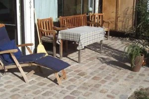 Terrasse aus Natursteinpflaster mit Gartenmöbeln