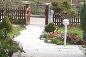 Plattenweg durch einen Vorgarten zum Gartentor